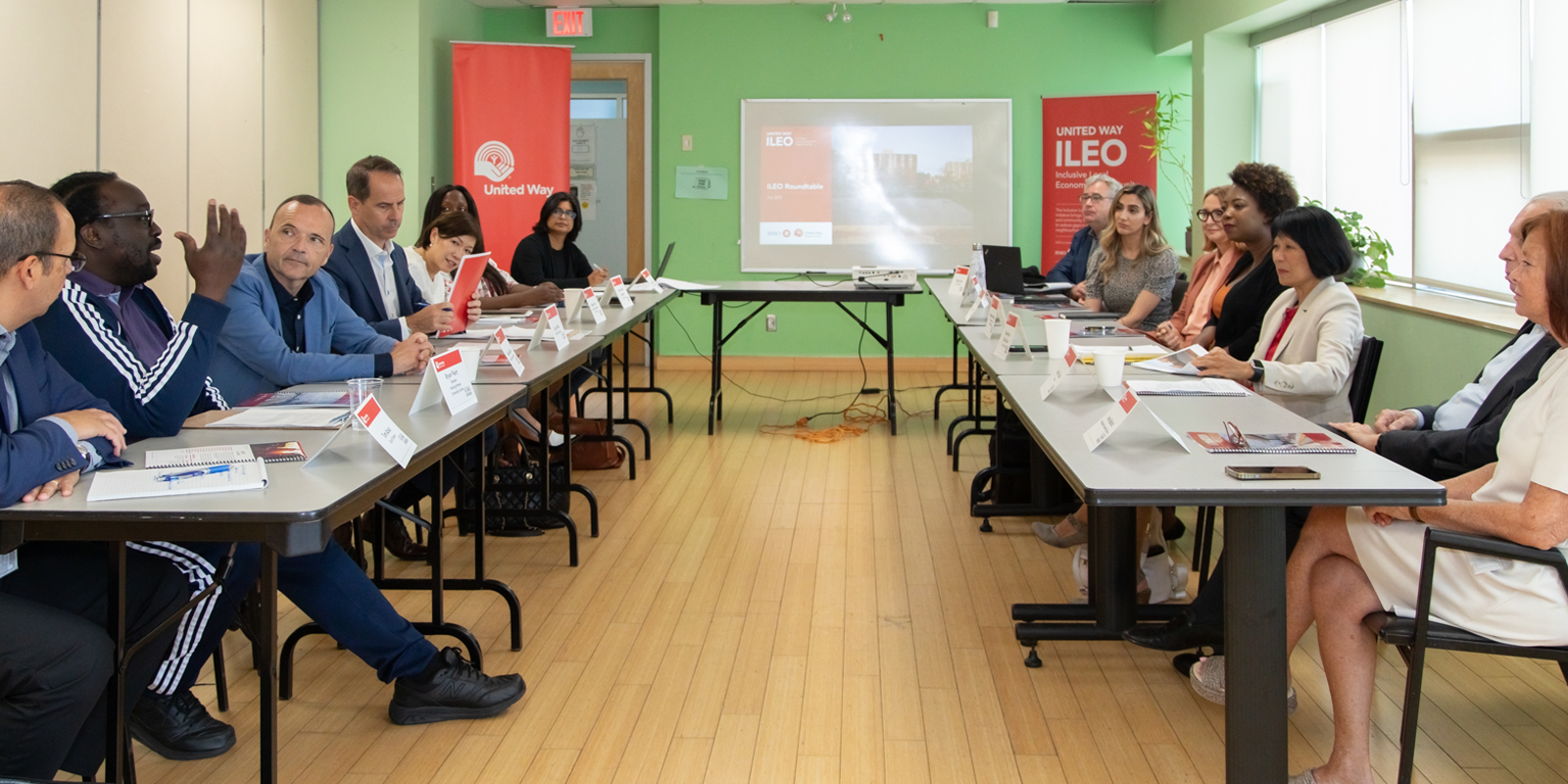 A group of people sitting around a table discussing ILEO