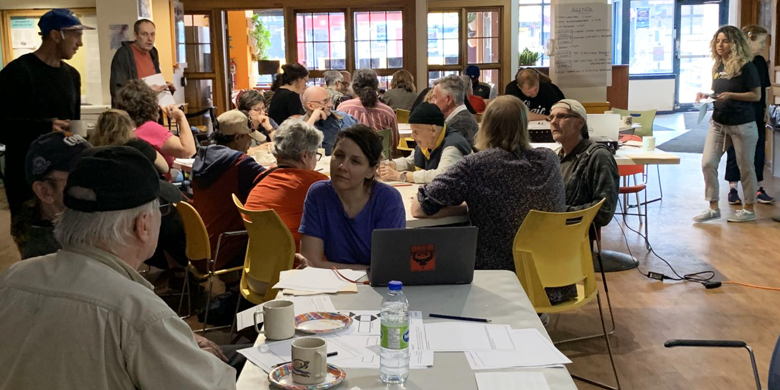 Many people sitting around tables at Parkdale Community Centre