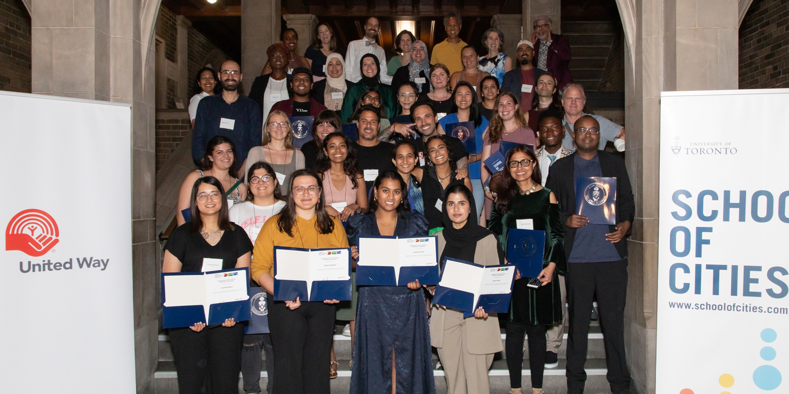 A group of people holding certificates after graduating from the University of Toronto's School of Cities program